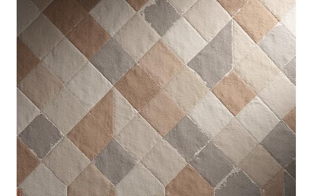 Teppe med grå, brun og beige toner i geometric patterns som minner om drivved, i et nordisk interiør.